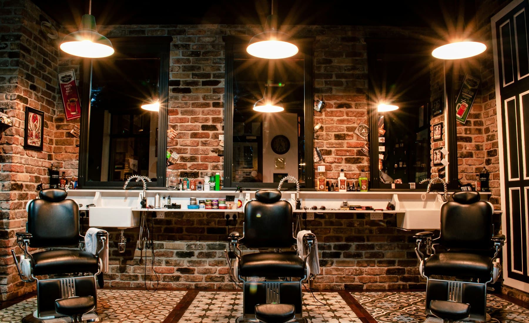 Interior de la barbería con sillas clásicas y paredes de ladrillo